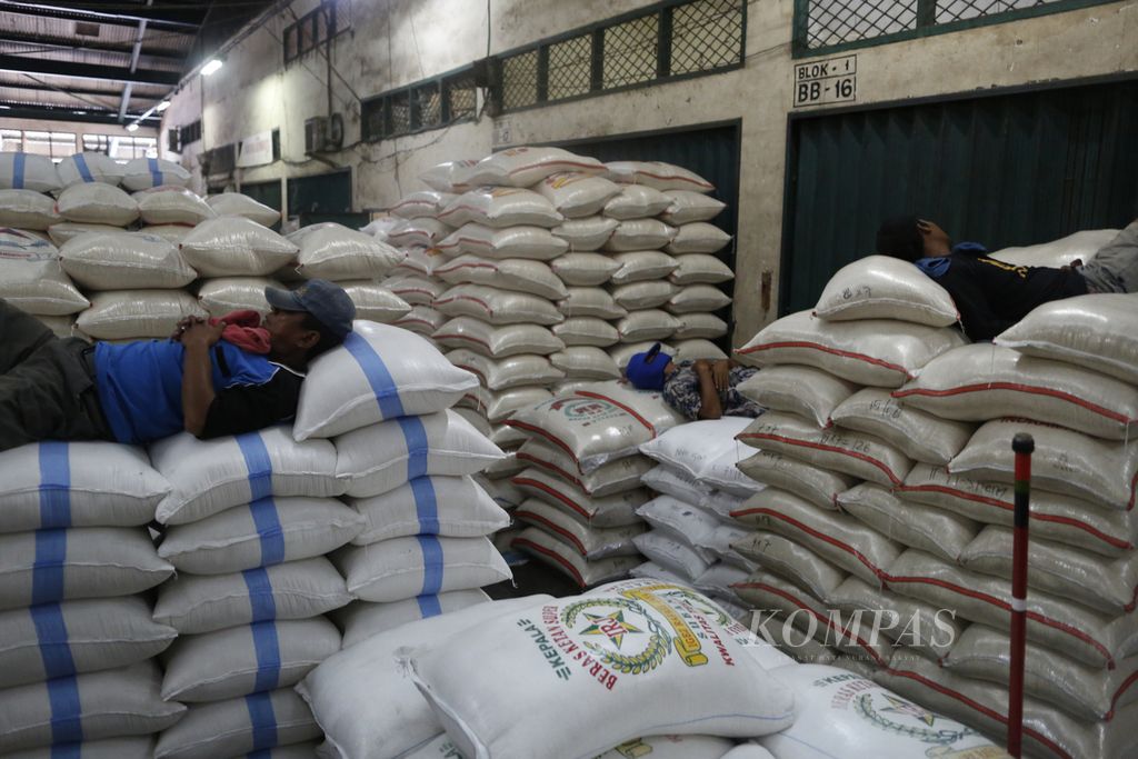 Buruh angkut terlelap sembari menunggu orderan mengangkut karung beras di Pasar Induk Beras Cipinang, Jakarta, Senin (3/10/2022). Pemerintah melalui Perum Bulog menggenjot serapan gabah dan beras dari petani. Saat ini stok beras Bulog sebanyak 800 ribu ton dan ditargetkan mencapai 1,2 juta ton.