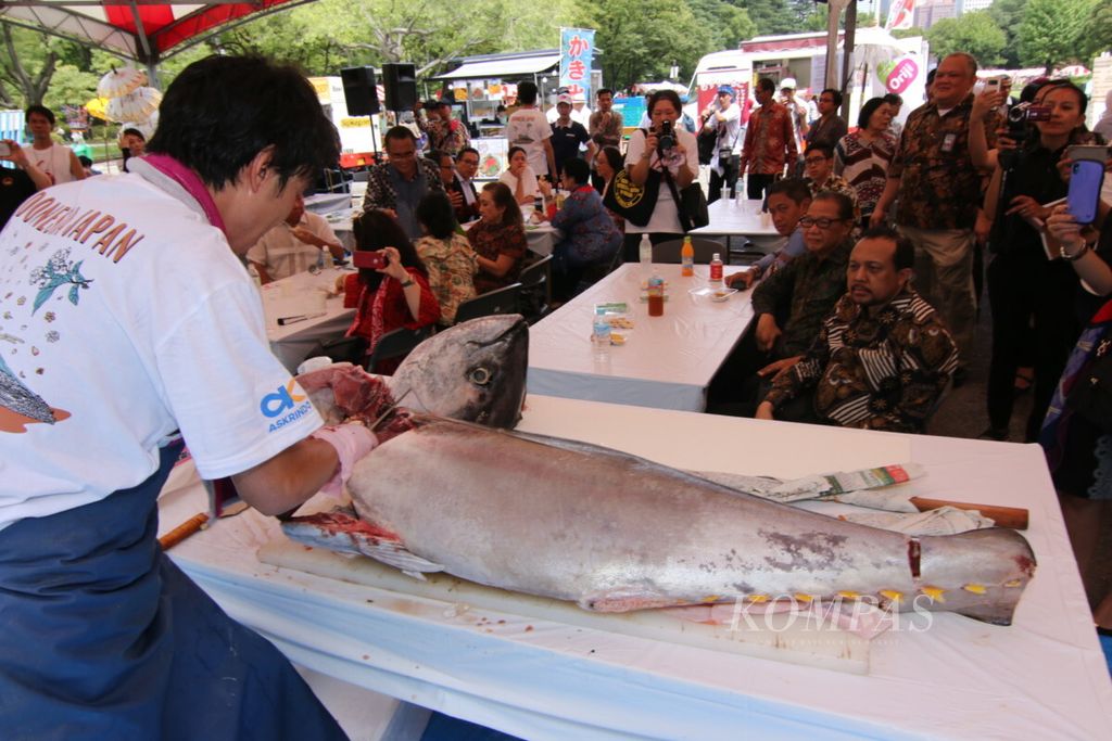  Seorang ahli pembuat <i>sushi</i> atau yang biasa disebut <i>itamae</i> tampak serius ketika memotong sejumlah bagian tubuh ikan tuna dalam Festival Indonesia di Hibiya Park, Tokyo, Jepang, Minggu (29/7). Makanan bisa menjadi pintu perkenalan dan minat warga asing untuk mempelajari bahasa Indonesia. 