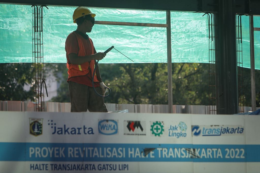 Seorang pekerja berdiri di Halte Transjakarta Gatot Subroto LIPI, Jakarta Selatan, Selasa (7/3/2023).