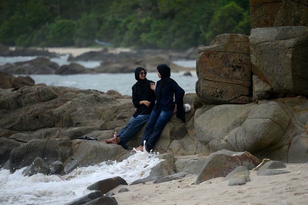 Remaja menikmati  suasana sore di obyek wisata Pantai Wedi Ombo, Gunungkidul, DI Yogyakarta, Rabu (24/1/2024). 