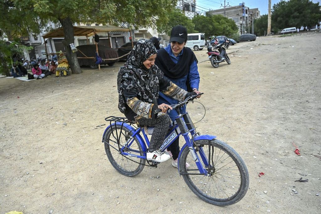 Pelatih mengemudi sepeda motor khusus perempuan Zainab Safdar (kanan) dan salah satu muridnya di Karachi, Pakistan, pada 5 Maret 2024.