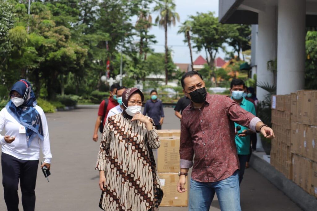 Menteri Sosial Tri Rismaharini mendengarkan penjelasan Wali Kota Surabaya Eri Cahyadi saat pemberian bantuan sarana kesehatan di Surabaya, Minggu (28/2/2021). Kementerian Sosial mendorong daerah meningkatkan kemandirian penanganan dan pencegahan bencana.