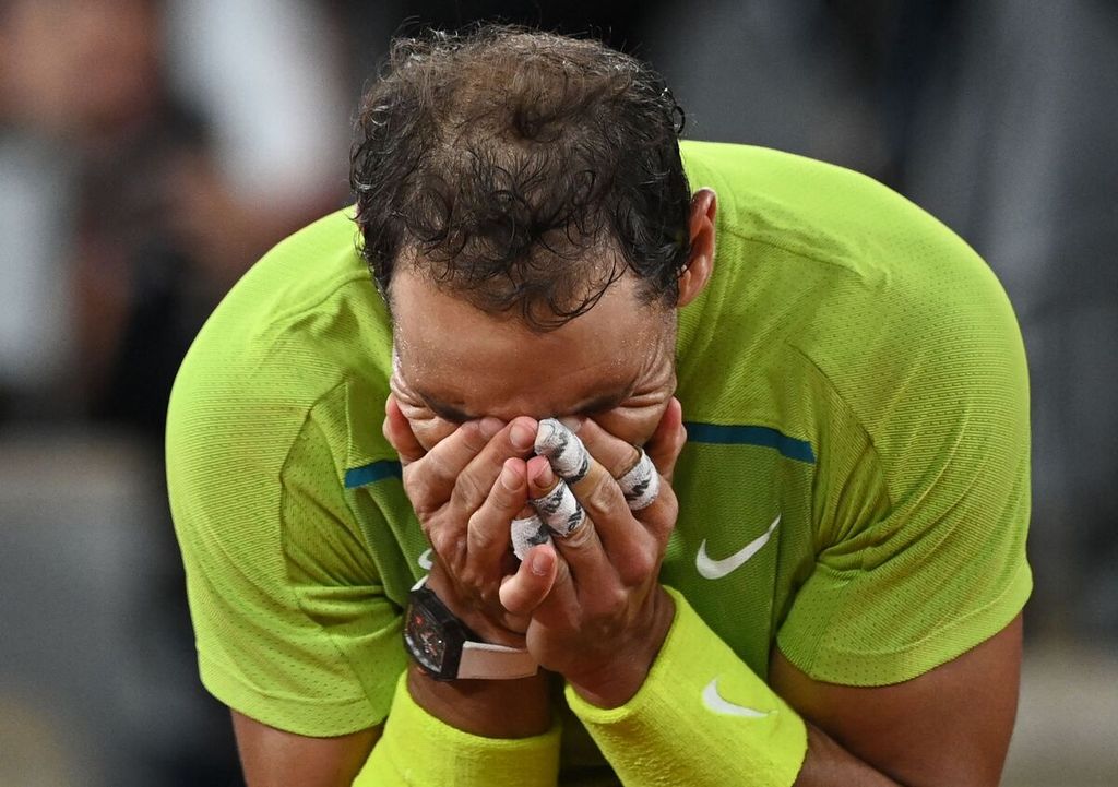 Petenis Spanyol Rafael Nadal menutup wajahnya setelah memastikan kemenangan atas Novak Djokovic, petenis nomor satu dunia, pada laga perempat final Grand Slam Perancis Terbuka di lapangan Philippe Chatrier, Roland-Garros, Paris, Rabu (1/6/2022).  