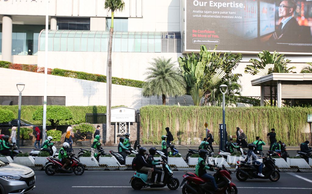 Pengemudi ojek daring menunggu penumpang di jalan protokol MH. Thamrin, Jakarta Pusat, Jumat (9/8/2024). Tak sedikit para pekerja yang terkena pemutusan hubungan kerja (PHK) yang banting setir menjadi pengemudi ojek daring.