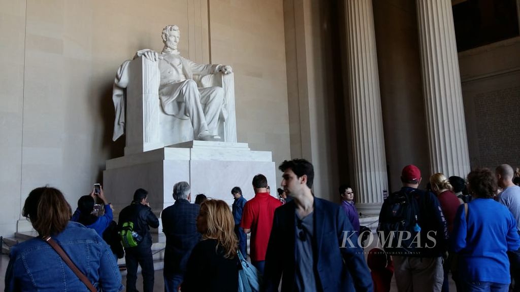 Para pengunjung berdiri di bawah patung Presiden ke-16 AS Abraham Lincoln di Lincoln Memorial, National Mall, Washington DC pada 23 Oktober 2015.