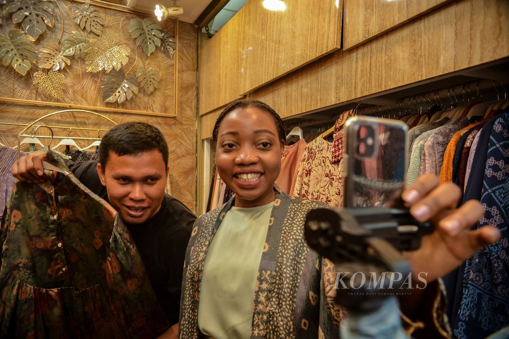 Dua pedagang sedang menawarkan dagangannya secara daring melalui siaran langsung di media sosial Tiktok di kios Blok A Tanah Abang, Jakarta, Selasa (13/6/2023). Penjualan secara daring menjadi salah satu strategi para pedagang untuk menjangkau konsumen yang lebih luas. 