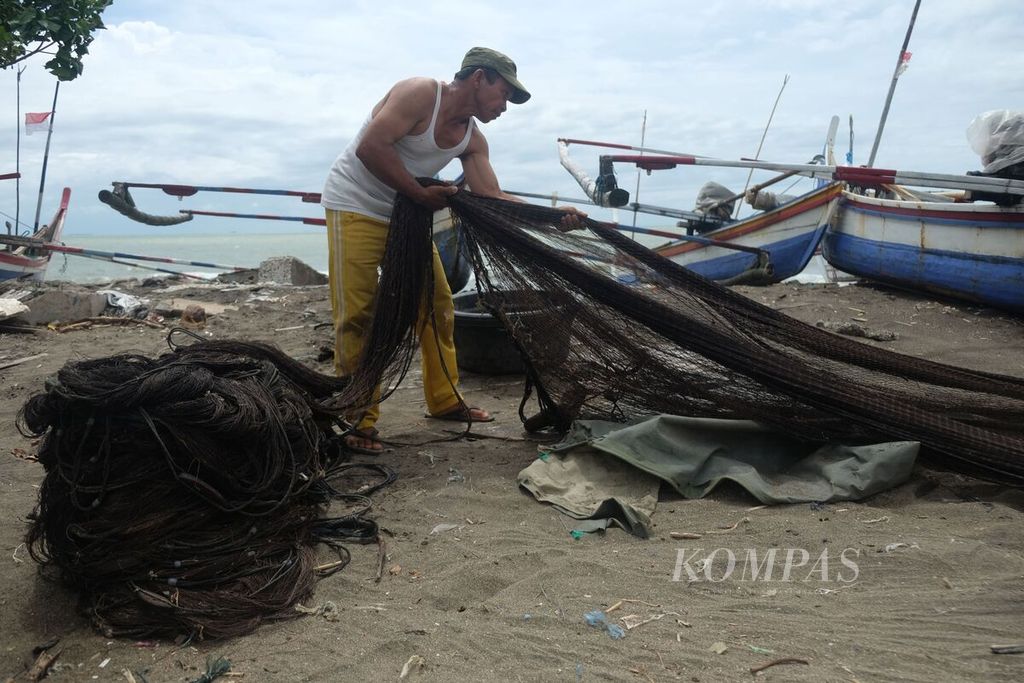 A fisherman in the Padang Beach area, Padang City, West Sumatra, straightens his net before returning to sea some time ago.