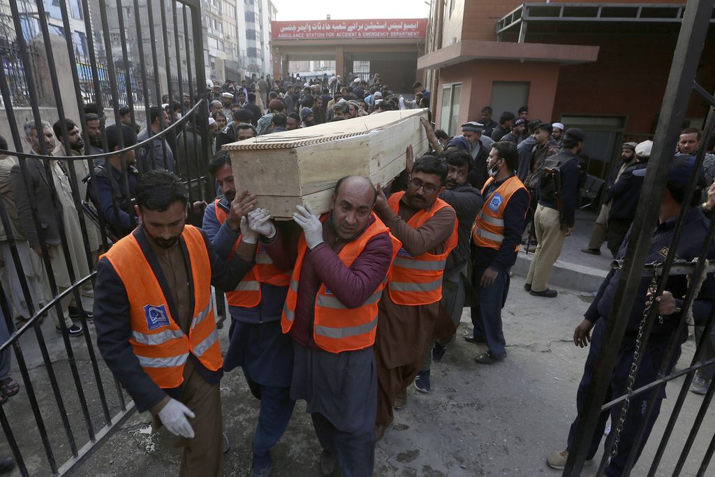 Sejumlah sukarelawan di rumah sakit di Peshawar mengusung peti mati berisi salah satu korban serangan bom bunuh diri, Senin (30/1/2023).  