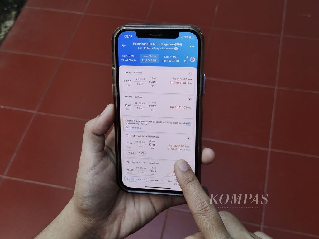 Warga mengecek tarif harga penerbangan internasional dari Palembang ke Singapura melalui aplikasi Traveloka, Kamis (9/5/2024).