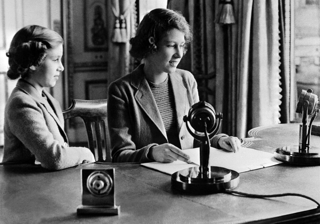 Puteri Elizabeth (kanan) didampingi saudaranya Puteri Margareth tengah menyampaikan pesan dalam satu program acara untuk anak-anak di BBC. Pesan itu khusus disampaikan untuk anak-anak yang tengah dievakuasi dari kemelut Perang Dunia II. Foto diambil pada 1 Oktober 1940 di Windsor, Inggris.