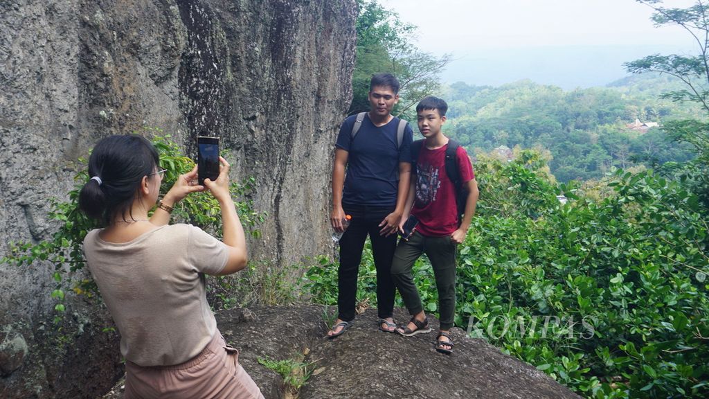 Wisatawan berfoto di Gunung Api Purba Nglanggeran. Desa Nglanggeran, Kecamatan Patuk, Kabupaten Gunung Kidul, DIY, Minggu (1/5/2022). 