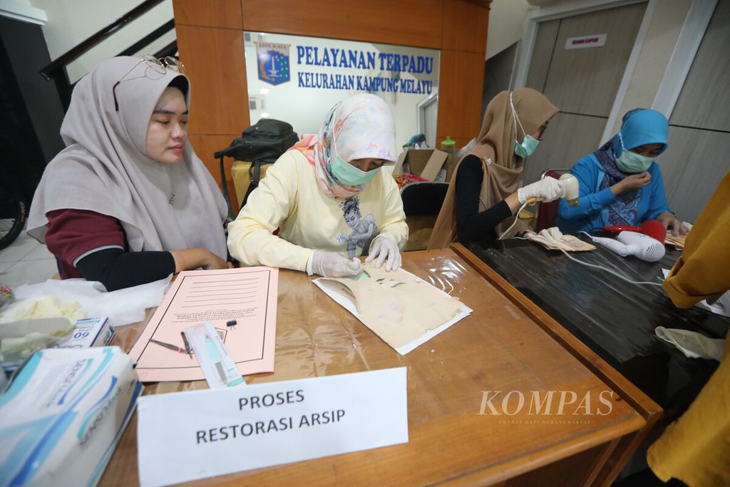 Staf Dinas Perpustakaan dan Arsip merestorasi dokumen pribadi masyakarat yang rusak terimbas banjir di kantor Kelurahan Kampung Melayu, Jakarta Timur, Sabtu (11/1/2020). 