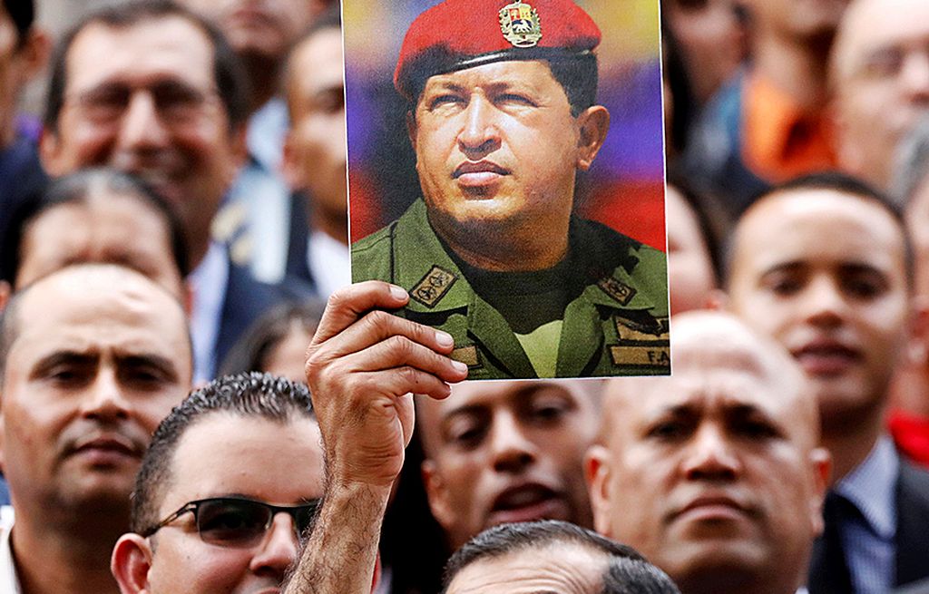 Anggota Majelis Konstitusi Venezuela mengacungkan foto mantan Presiden Hugo Chavez saat sesi foto bersama anggota lain pada sidang pertama majelis di gedung parlemen, Caracas, Jumat (4/8).