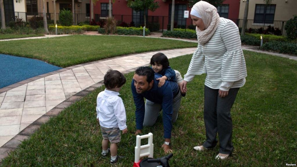 Warga Suriah yang mendapat status imigrasi <i>temporary protected status</i> (TPS), Mohammad Alala dan istrinya, keduanya dari Suriah, dengan dua anak mereka yang lahir di Amerika Serikat, Taim dan Amr, bermain di taman dekat rumah mereka di Miramar, Florida, 24 Januari 2018.