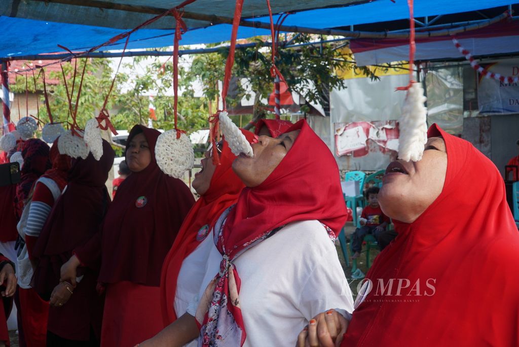 Kalangan ibu-ibu mengikuti lomba makan kerupuk dalam peringatan Hari Ulang Tahun Kemerdekaan Ke-78 Republik Indonesia di RT 03 RW 05, Kelurahan Dadok Tunggul Hitam, Kota Padang, Sumatera Barat, Kamis (17/8/2023). 