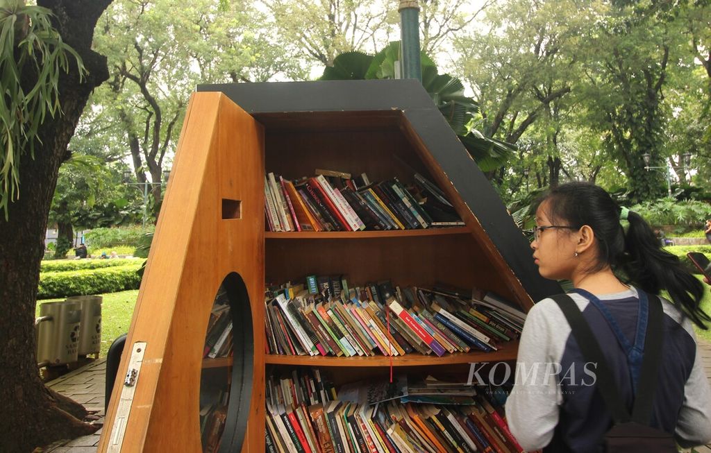 Pengunjung melihat buku yang tersimpan dalam lemari Bookhive di Taman Suropati, Menteng, DKI Jakarta, Minggu (17/7/2022). Pengunjung dapat mengambil dan menitipkan buku di lemari itu. Kehadiran lemari tersebut mendekatkan akses terhadap bacaan di ruang publik.