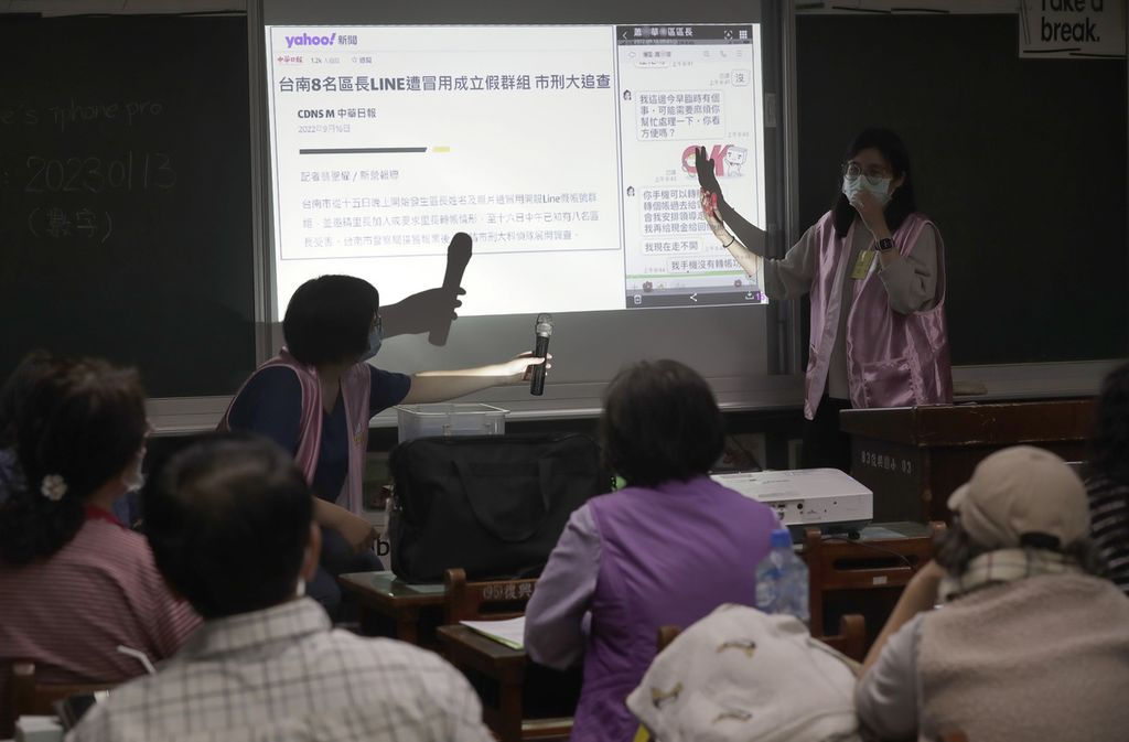 Sukarelawan Pembersih Berita Palsu membimbing siswa para lansia melalui aplikasi Line untuk mengidentifikasi berita palsu selama kelas di kota Kaohsiung, Taiwan, 16 Maret 2023. 