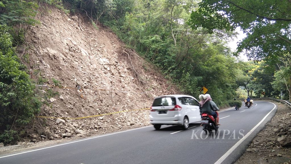 Kendaraan bermotor melintas di tebing bekas longsor di daerah Payung, Songgokerto, Kota Batu, Jawa Timur, Rabu (17/3/2021).