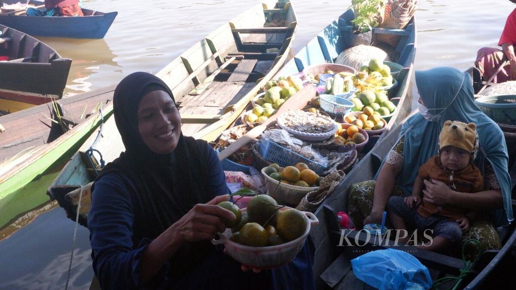 Seorang pedagang menawarkan buah jeruk siam banjar di Pasar Terapung Lok Baintan, Kecamatan Sungai Tabuk, Kabupaten Banjar, Kalimantan Selatan, Sabtu (18/9/2021). 