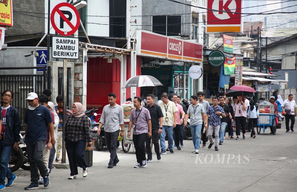 Rombongan karyawan berjalan menyusuri deretan warung makan saat jam istirahat siang di kawasan Setiabudi, Jakarta Selatan, Selasa (21/11/2023).  