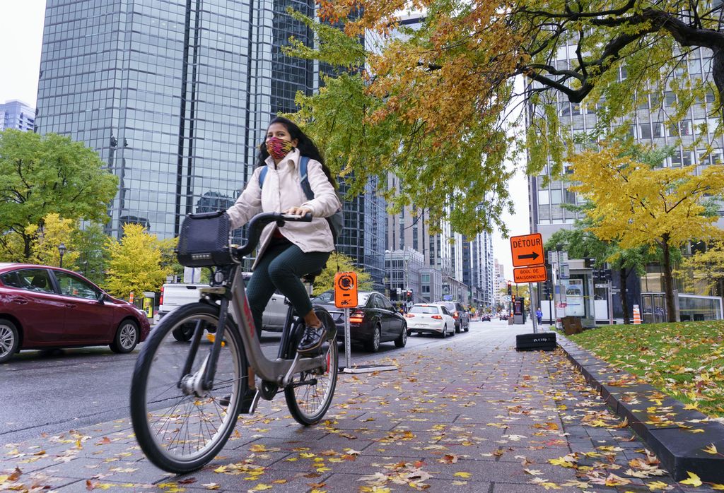 Seorang perempuan mengendarai sepeda di pusat kota Montreal, Kanada, 20 Oktober 2020. Montreal adalah kota yang paling agresif di antara banyak kota di Amerika Utara yang memperluas jaringan sepeda.