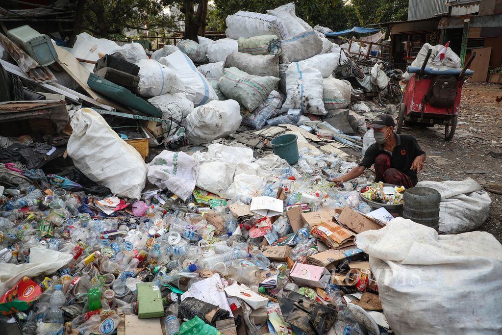 Seorang pemulung memilah sampah yang bisa dijual di Kampung Gasong, Menteng Atas, Jakarta Selatan, Senin (21/8/2023).