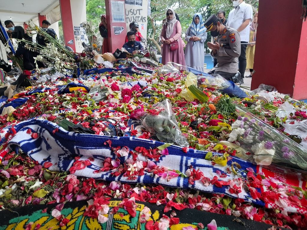Kepala Polres Malang yang baru, Ajun Komisaris Besar (AKB) Putu Kholis Aryana, Selasa (11/10/2022), berdoa di depan hamparan bunga tabur yang menumpuk di depan Pintu 13 Stadion Kanjuruhan. 