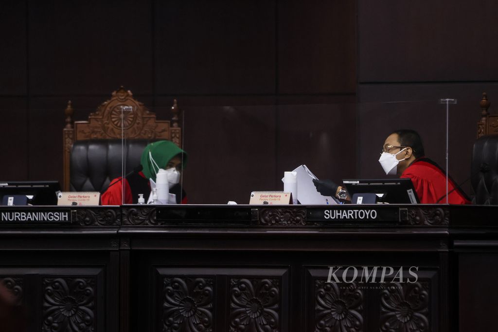 Hakim konstitusi Eny Nurbaningsih (kiri) berbincang dengan hakim konstitusi Suhartono saat persidangan pembacaan keputusan terkait uji materi Undang-Undang Nomor 19 Tahun 2019 tentang Komisi Pemberantasan Korupsi hasil revisi di Gedung Mahkamah Konstitusi, Jakarta, Selasa (4/5/2021). 