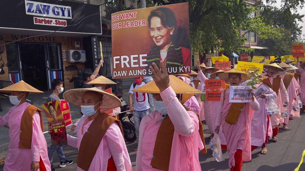 Para biarawati Buddha membawa foto pemimpin Myanmar yang digulingkan Aung San Suu Kyi selama pawai jalanan di Mandalay, Myanmar, Jumat (26/2/2021). 