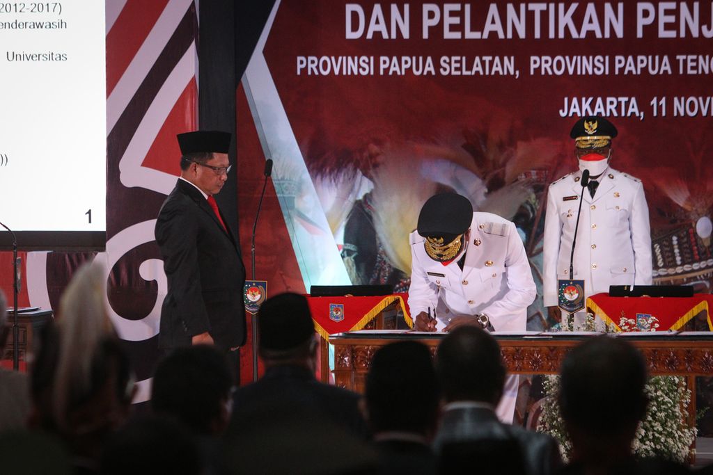 Penjabat Gubernur Papua Selatan Apolo Safanpo (tengah) menandatangani surat pelantikan disaksikan Menteri Dalam Negeri Tito Karnavian (kiri) di Kementerian Dalam Negeri, Jakarta, Jumat (11/11/2022). 
