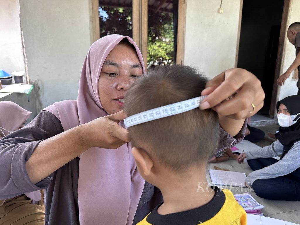Kader Posyandu Dusun Bongor Mekarasi mengukur lingkar kepala anak balita dalam kegiatan Posyandu Keluarga di Dusun Bongor, Desa Taman Ayu, Lombok Barat, Nusa Tenggara Barat, Selasa (12/12/2023). Posyandu Keluarga yang saat ini berjumlah lebih dari 7.700 unit menjadi salah satu bagian penting dalam pencegahan dan penurunan angka tengkes (<i>stunting</i>) di Nusa Tenggara Barat.