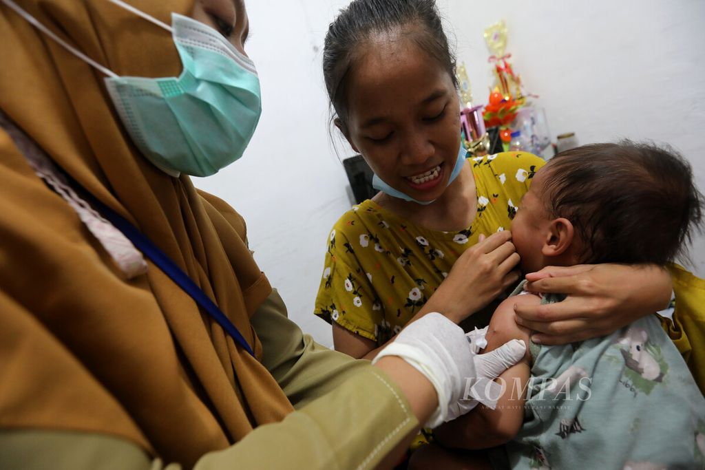 Petugas kesehatan menyuntikkan imunisasi campak kepada seorang anak balita di Posyandu RW 005, Rawa Terate, Cakung, Jakarta Timur, Selasa (14/2/2023).