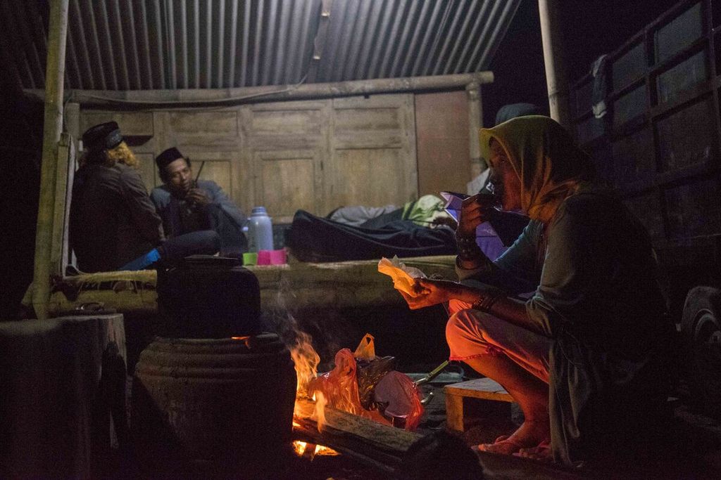Warga di Dusun Trono, Desa Krinjing, Kecamatan Dukun, Kabupaten Magelang, Jawa Tengah, berjaga hingga pagi untuk mengamati aktivitas Gunung Merapi yang statusnya Siaga III, Jumat (20/11/2020).