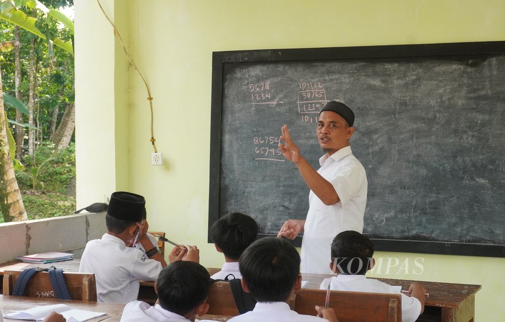 Guru tengah mengajar siswa kelas V Madrasah Ibtidaiyah Pasawahan, Kecamatan Banjaranyar, Kabupaten Ciamis, Jawa Barat, Selasa (19/7/2022). 