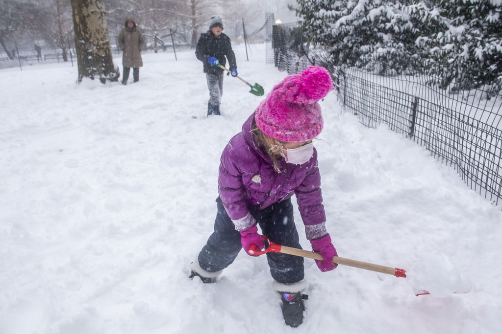 Warga bermain di Taman Washington, New York, pada Sabtu (29/1/2022) siang. Hampir seluruh negara bagian di pesisir timur Amerika Serikat dilanda badai salju pada akhir pekan ini. Di beberapa negara bagian, salju dilaporkan mencapai 60 centimeter.