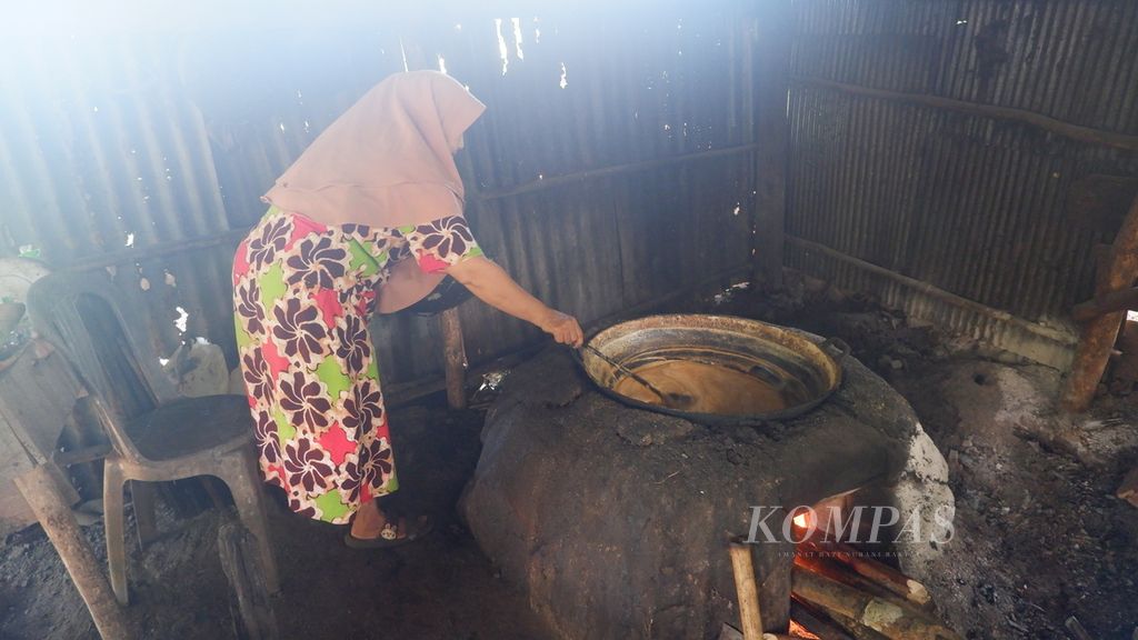 Hasnawati (52) mengaduk-aduk nira saat dimasak dalam proses pembuatan gula aren di kawasan Bukit Mamake, Desa Sarang Tiung, Kecamatan Pulau Laut Sigam, Kabupaten Kotabaru, Kalimantan Selatan, Selasa (5/7/2022).