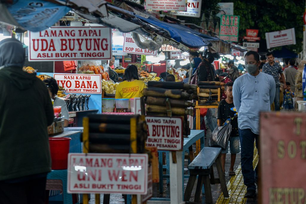 Warga berjalan di kawasan kuliner Jalan Kramat Raya, Jakarta Pusat, Jumat (14/4/2023). Sentra kuliner di kawasan Kramat Raya dengan makanan khas Minang, yakni nasi kapau, menjadi salah satu pilihan warga untuk berbuka puasa.