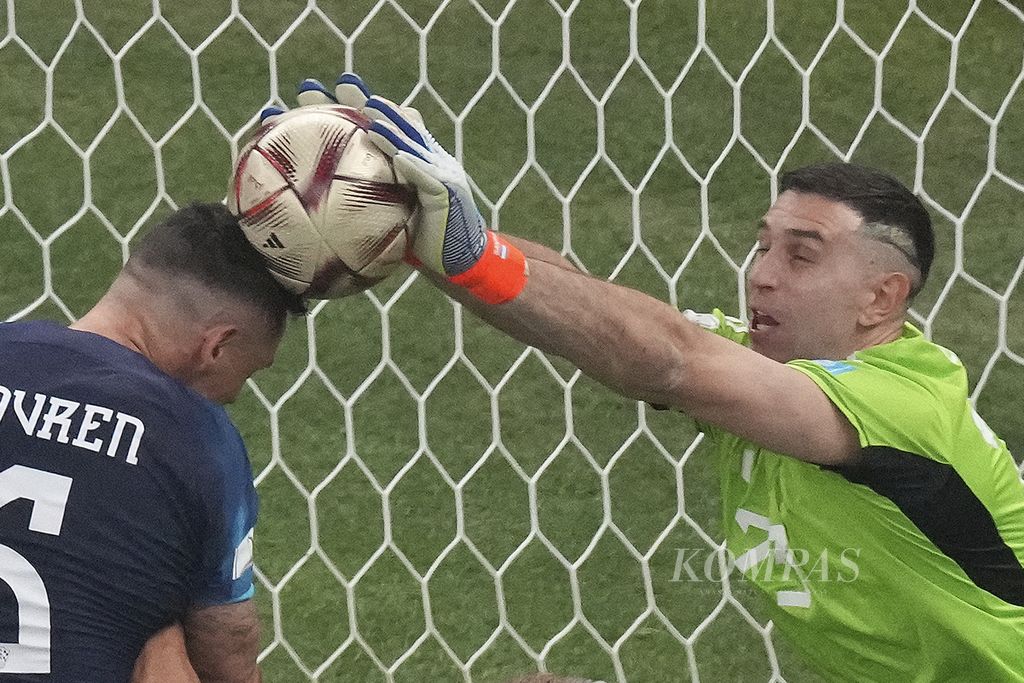 Kiper Argentina Emiliano Martinez berebut bola dengan pemain Kroasia Dejan Lovren di babak semifinal Piala Dunia 2022 di Stadion Lusail, Qatar, Rabu (14/12/2022) dini hari WIB. Argentina melaju ke final Piala Dunia 2022 setelah mengalahkan Kroasia 3-0. 