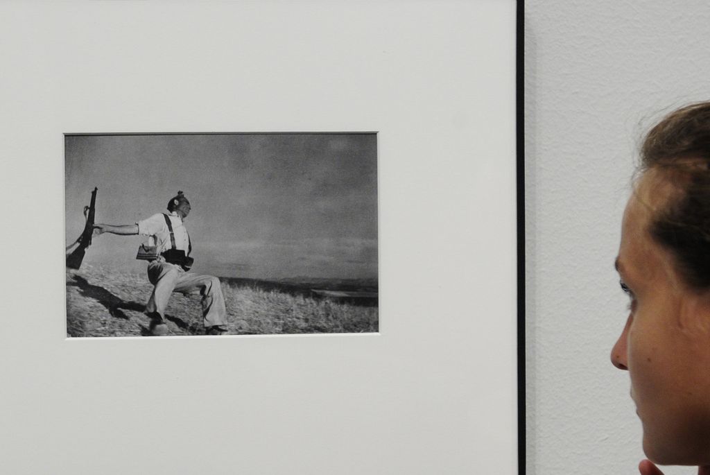 Seorang pengunjung melihat foto Falling Militiaman karya Robert Capa di pameran This is war! Robert Capa at work, di Museo Nacional dArt de Catalunya, di Barcelona, Rabu, 22 Juli 2009. Foto Robert Capa yang mengabadikan anggota milisi Perang Saudara Spanyol yang jatuh menjadi salah satu gambar paling terkenal dan abadi dari konflik di abad ke-20 menurut peneliti Spanyol yang telah mempelajari peristiwa seputar foto tersebut. 