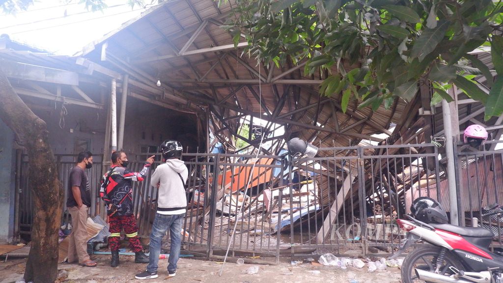 Warga melihat bangunan rumah makan Tenda Biru yang roboh tertimpa bangunan toko Alfamart yang ambruk di Kecamatan Gambut, Kabupaten Banjar, Kalimantan Selatan, Selasa (19/4/2022), setelah semua korban ditemukan. 