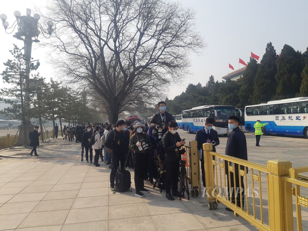 Jurnalis mengantre di luar Gedung Aula Besar Rakyat, Lapangan Tiananmen, Beijing, China, sebelum diizinkan masuk untuk meliput konferensi pers juru bicara Kongres Rakyat Nasional (NPC), Sabtu (4/3/2023).