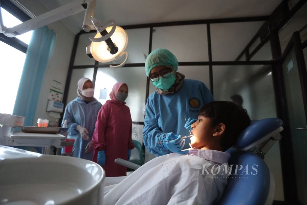 Murid SD mendapat layanan pemeriksaan kesehatan gigi dan mulut di Rumah Sakit Gigi dan Mulut Soelastri, Kota Surakarta, Jawa Tengah, Senin (20/3/2023).  