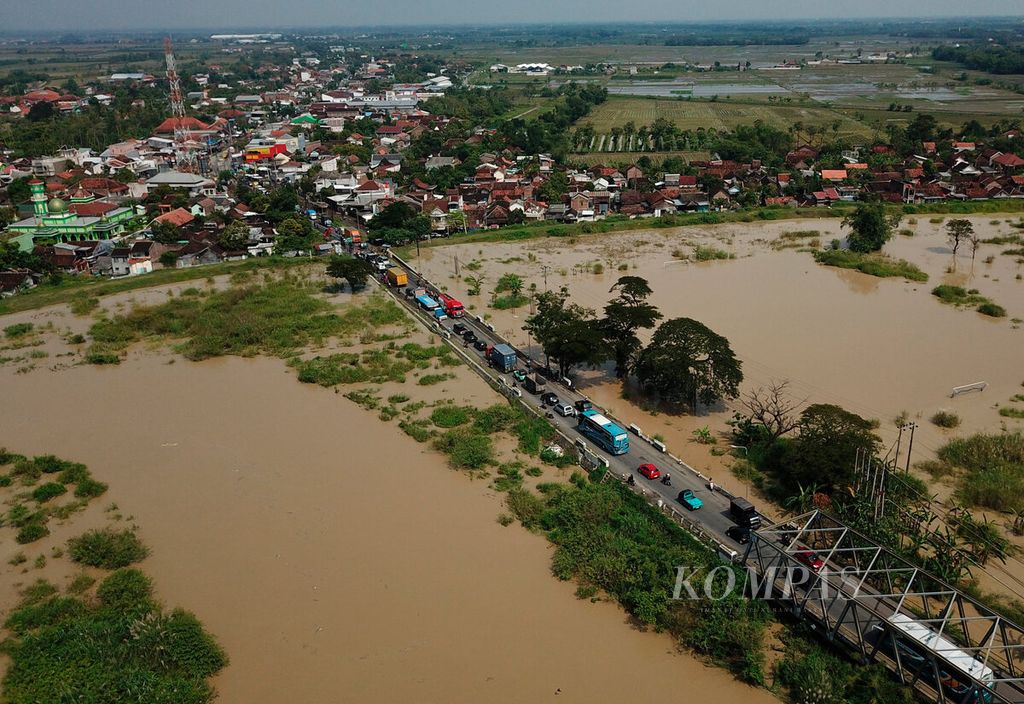 Antrean kendaraan akibat jalan rusak dan banjir di jalur Semarang-Grobogan di Kecamatan Gubug, Kabupaten Grobogan, Jawa Tengah, Rabu (29/3/2023). 