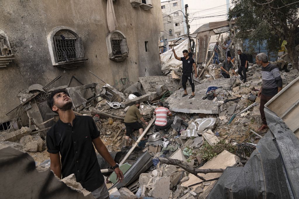 Warga Palestina memeriksa reruntuhan setelah serangan udara Israel atas Khan Younis, Jumat (27/10/2023).