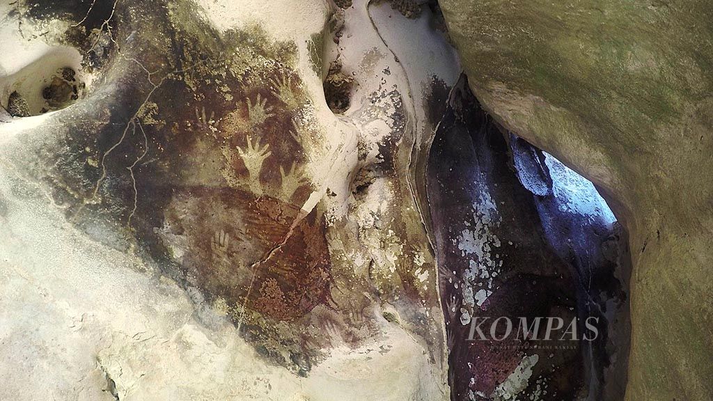 Lukisan telapak tangan dan babirusa di salah satu dinding goa di Taman Prasejarah Leang Leang, Maros, Sulawesi Selatan. Seni cadas berusia ribuan hingga puluhan ribu tahun banyak terdapat di goa yang tersebar di Taman Nasional Bantimurung-Bulusaraung. Ada lebih dari 200 goa di kawasan ini dan lebih dari setengahnya adalah goa prasejarah.