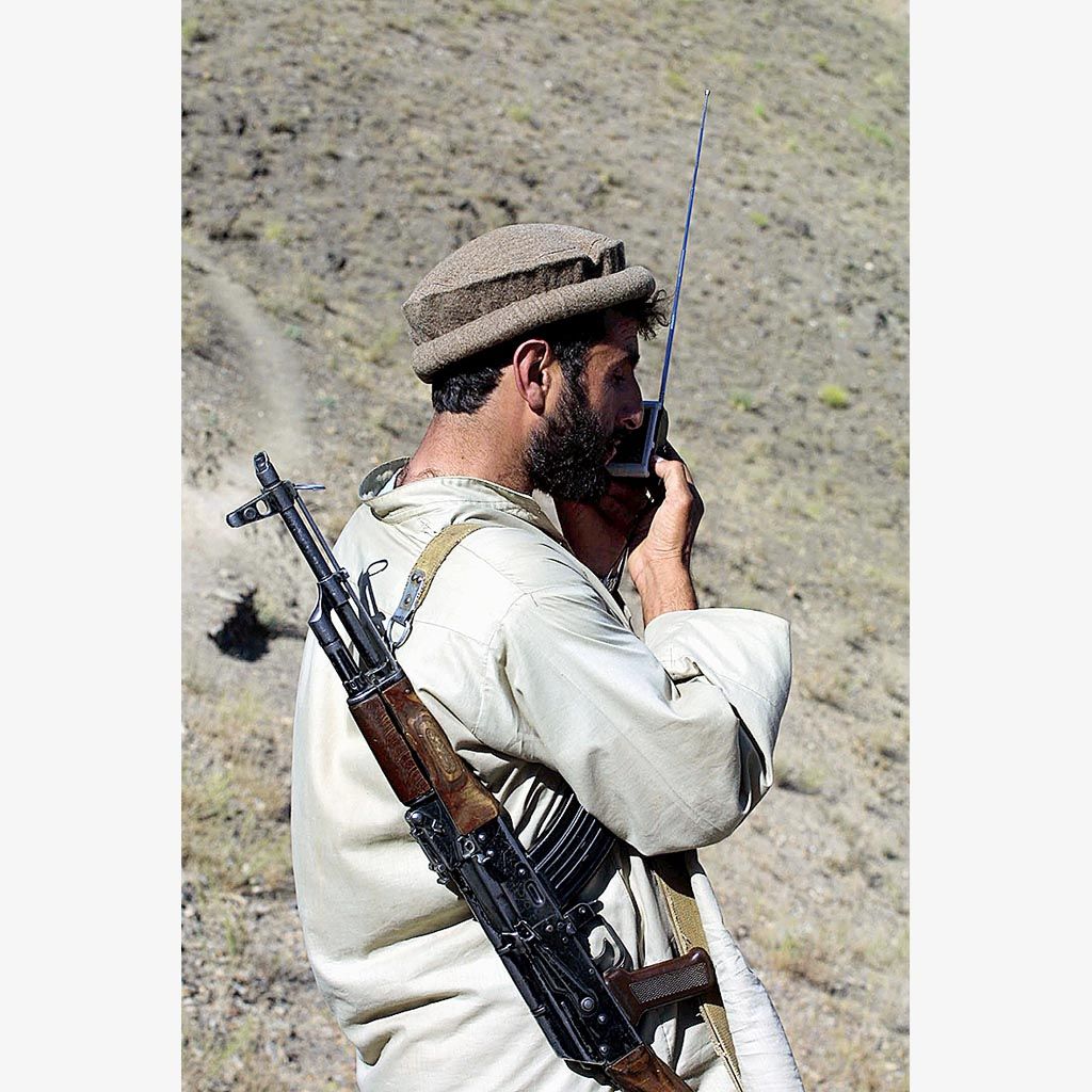 Seorang milisi Afghanistan mendengarkan radio di garis depan pertempuran melawan Taliban, 48 kilometer utara Kabul, Afghanistan,  2 Oktober 2001.
