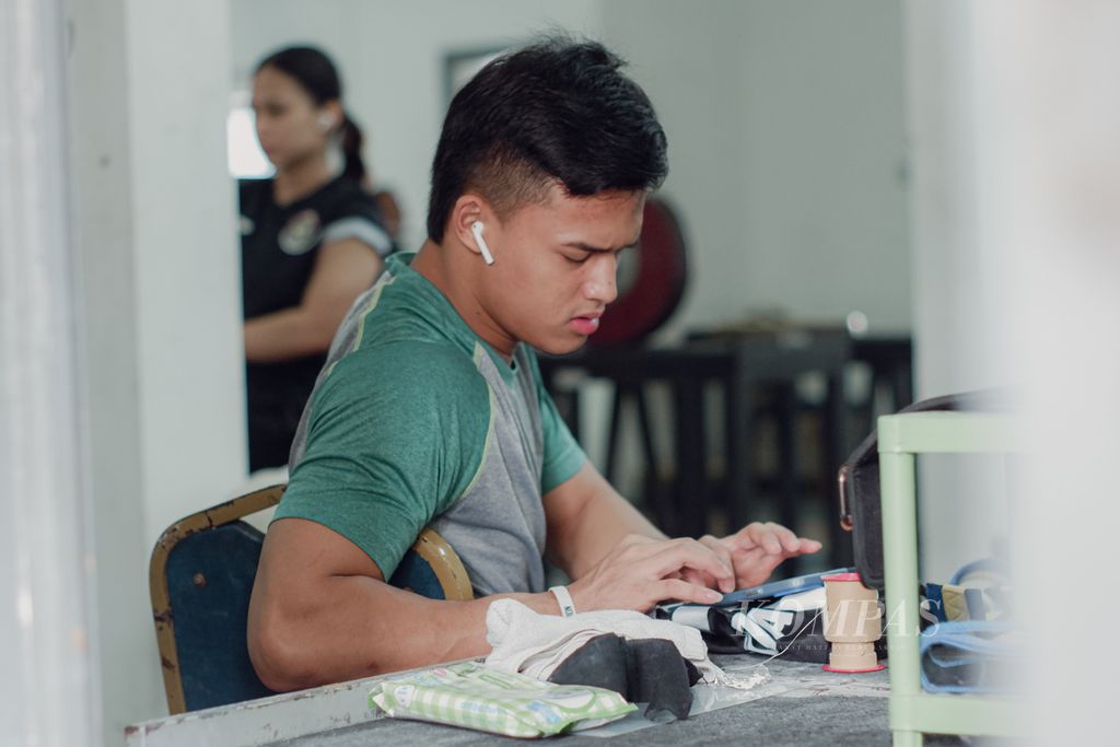 Lifter Indonesia, Rizki Juniansyah, sedang memilih lagu sebelum menjalani persiapan Olimpiade Paris 2024 di Mess Kwini, Jakarta, Jumat (24/5/2024). 