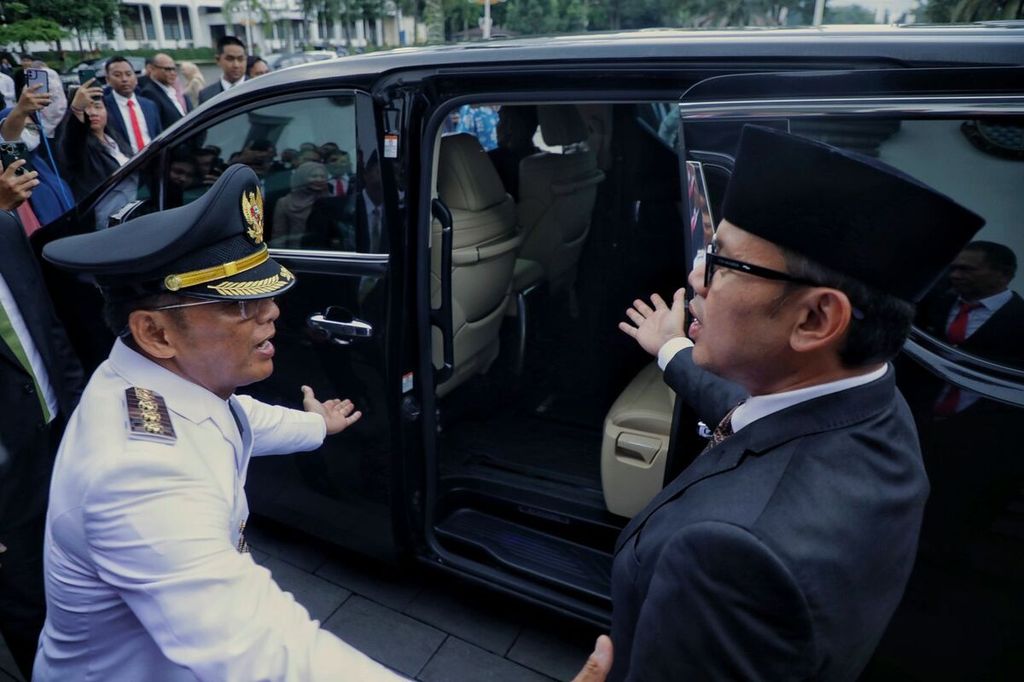 Penjabat Wali Kota Bogor Hery Antasari dan mantan Wali Kota Bogor Bima Arya saling mempersilakan untuk masuk dalam mobil seusai pelantikan Hery di Gedung Sate, Kota Bandung, Jawa Barat, Sabtu (20/4/2024).
