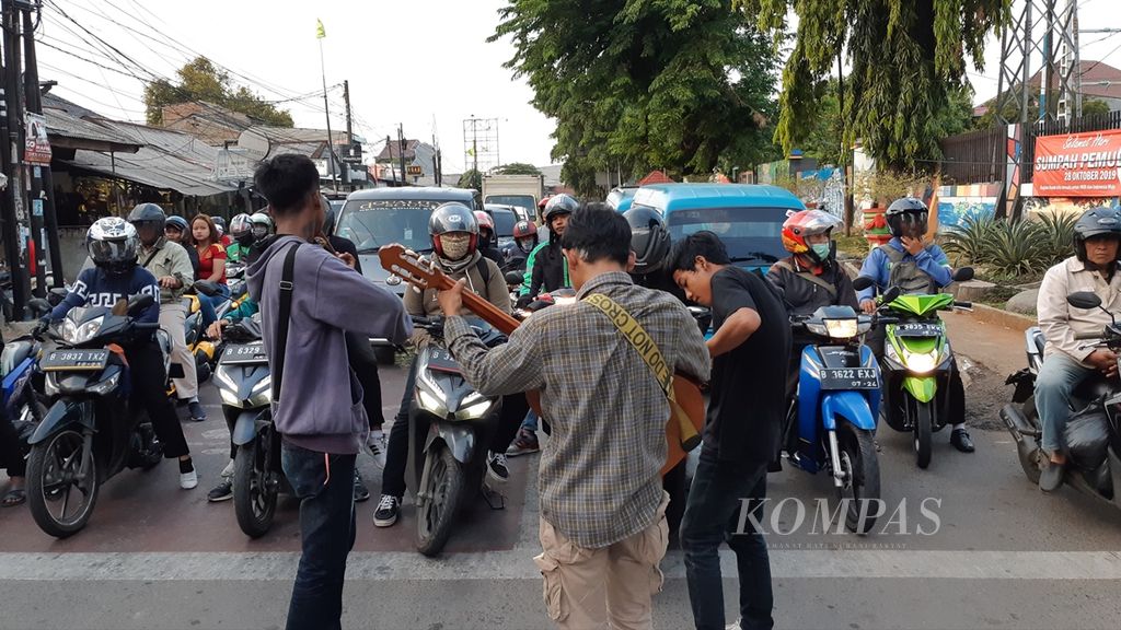 Anak jalanan Depok, Jawa Barat, mengamen di salah satu perempatan jalan, 20 November 2019.