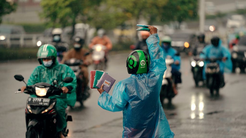 Penjual menawarkan jas hujan kepada pengguna jalan di Jalan Gatot Subroto, Jakarta, Selasa (21/12/2021). BMKG memperkirakan hujan dengan intensitas ringan hingga sedang masih akan terjadi di Jabodetabek.